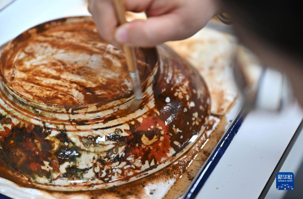 10月10日、文化財の表面をきれいにして修復を行う中國（海南）南海博物館の職員（撮影?郭程）。